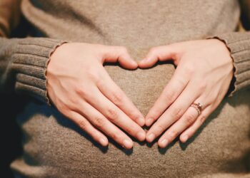 hands on a pregnant stomach forming a heart