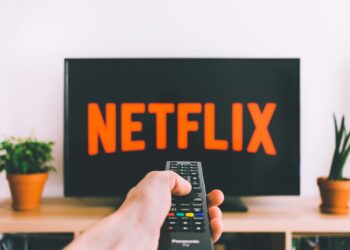 person holding remote pointing at TV