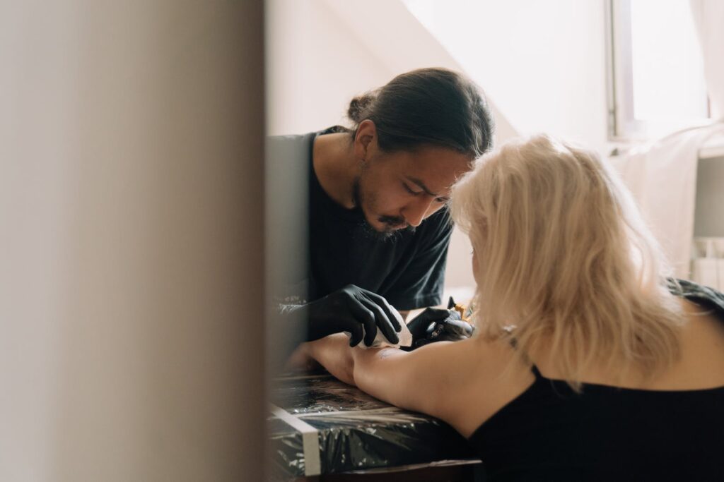 Back View of a Woman Getting a Tattoo on her Arm