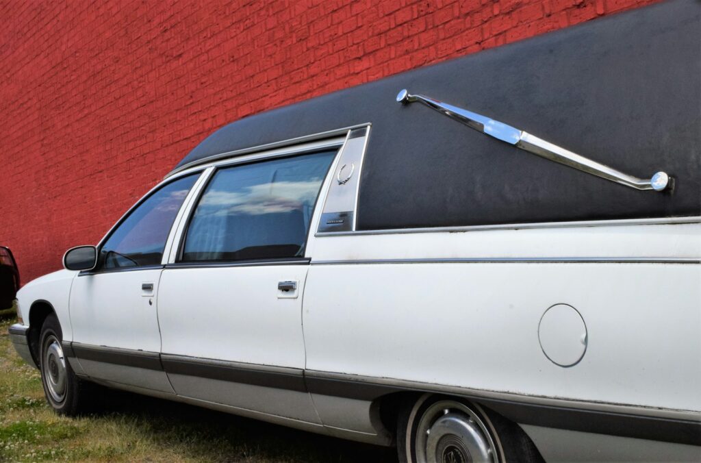 a white car parked in front of a red wall