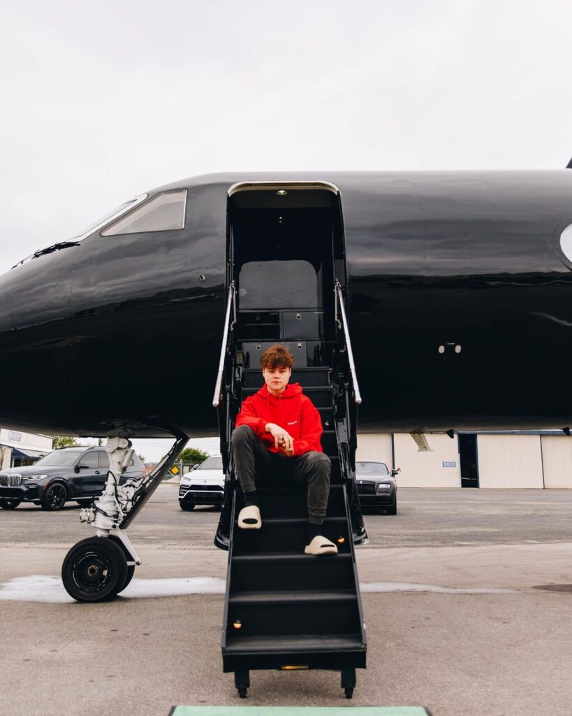 Jack Doherty sitting on a private jet stairs