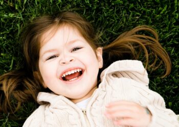 girl lying on grass laughing