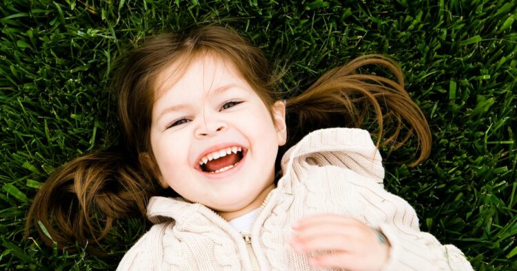 girl lying on grass laughing