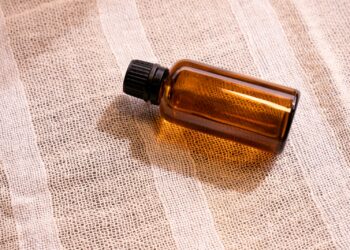 a bottle of essential oil sitting on a cloth