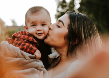 mother kissing young child