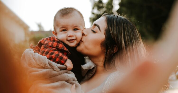 mother kissing young child