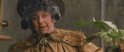 A gif of Professor Sprout from Harry Potter holding a mandrake plant.