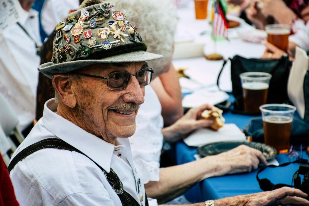 Smiling Man Sitting in Front of Blue Table