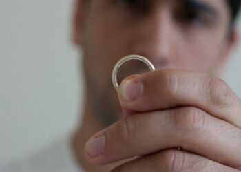 Man holding up a marriage ring (Eric Mesa via Flickr)