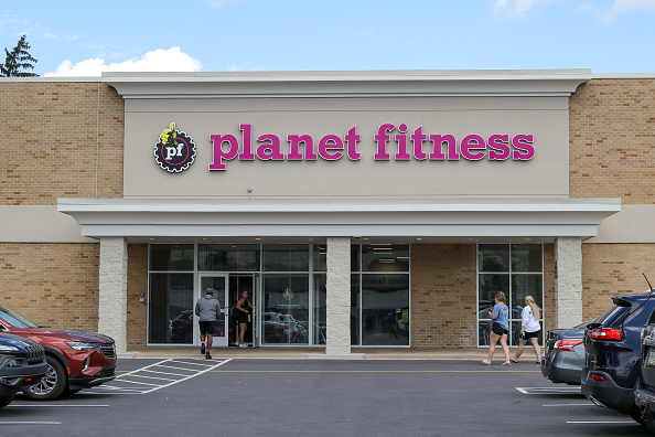 People are seen entering a Planet Fitness franchise. Planet...