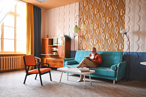 Senior man relaxing at interior with vintage furniture.