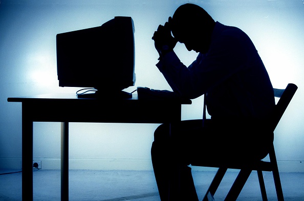 A silhouetted man sits working on a computer, 25 June 1997. AFR Picture by JESS
