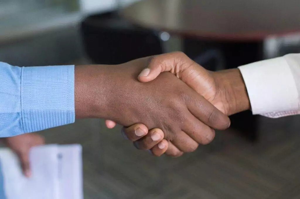 Two people shaking hands (Unsplash | Cytonn Photography)