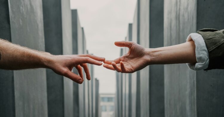 Two hands touching for support (Toa Heftiba via Unspalsh)
