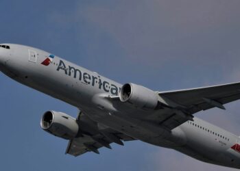 white and red passenger plane flying in the sky during daytime