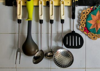 A kitchen with a bunch of utensils hanging on the wall