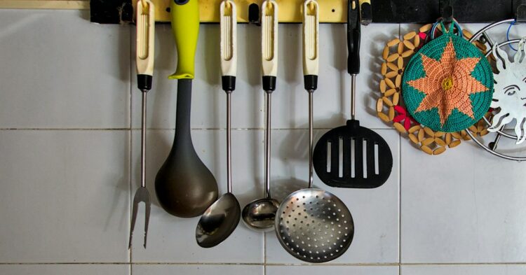 A kitchen with a bunch of utensils hanging on the wall