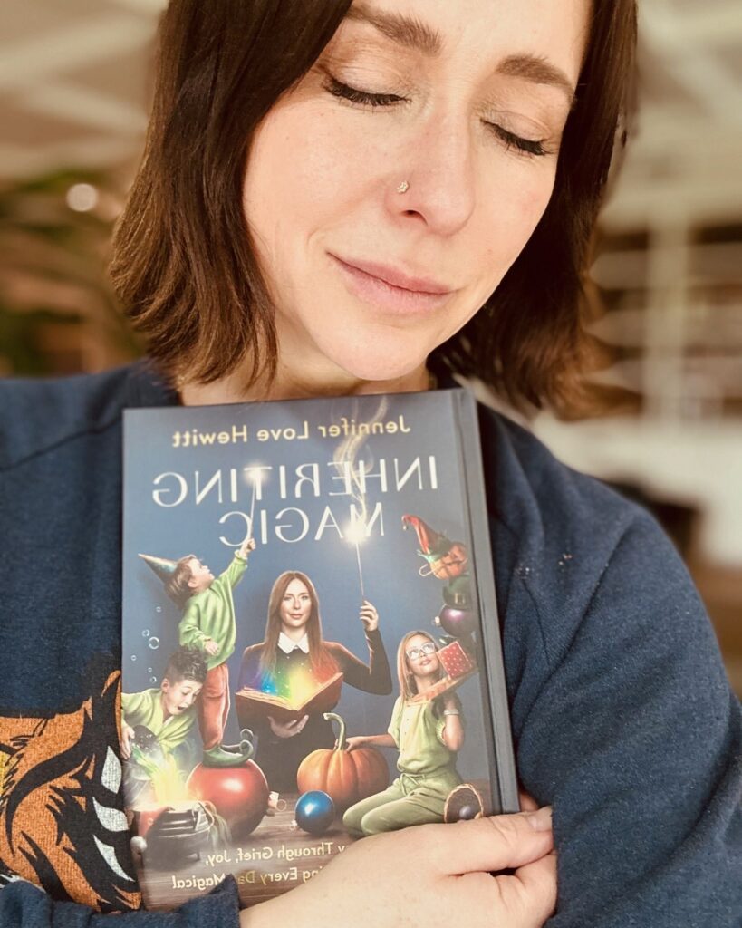 Jennifer Love Hewitt holds her new book Inheriting Magic.