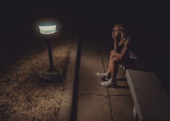 woman in black tank top sitting on concrete floor