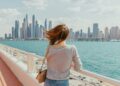 A woman standing on a bridge looking at the city