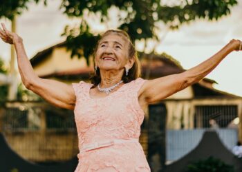 older woman with her hands raised up in the air