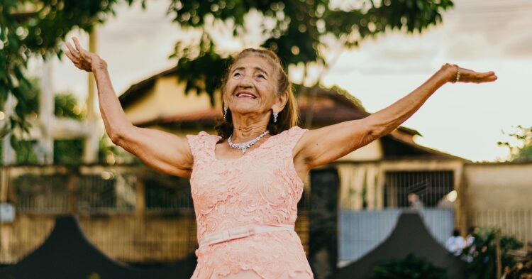 older woman with her hands raised up in the air