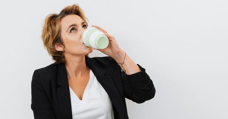woman sipping on coffer from a tumbler