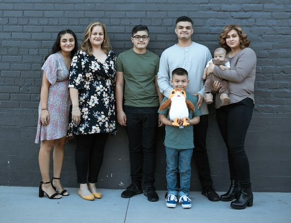 People standing against a gray wall