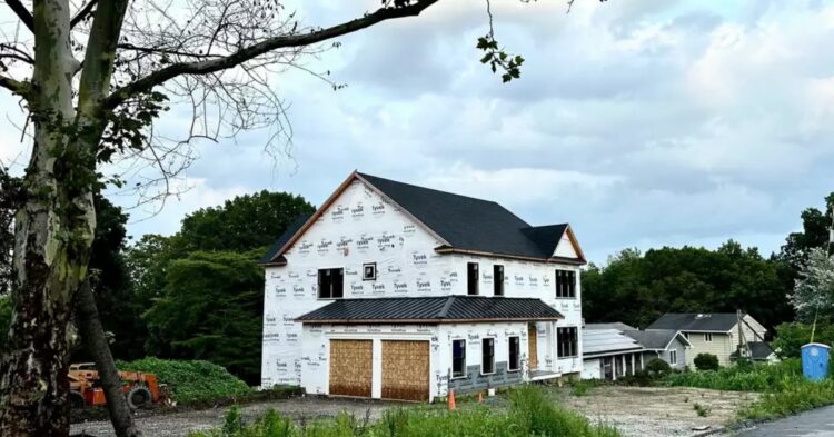A luxurious $1.5 million house stands on a piece of land, with a legal dispute looming over its ownership, after the original landowner returns to find it built