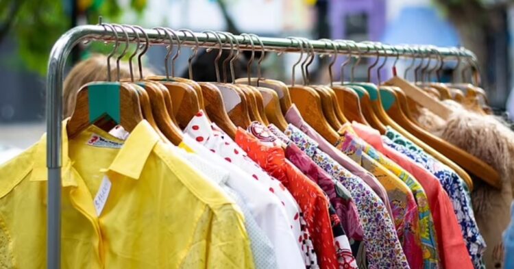A stack of second-hand clothes, showcasing vintage shirts and jackets, emphasizing the need for hygiene precautions.