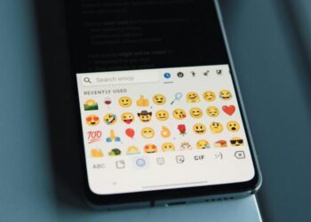 A collection of various small emojis, including smiley faces, hearts, and other expressions, scattered across the image.