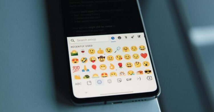 A collection of various small emojis, including smiley faces, hearts, and other expressions, scattered across the image.