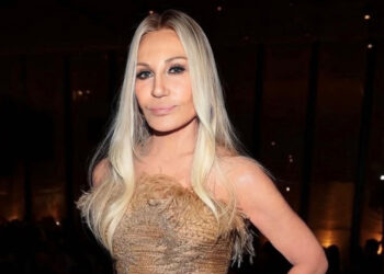 Designer Donnatella Versace poses in a gold gown