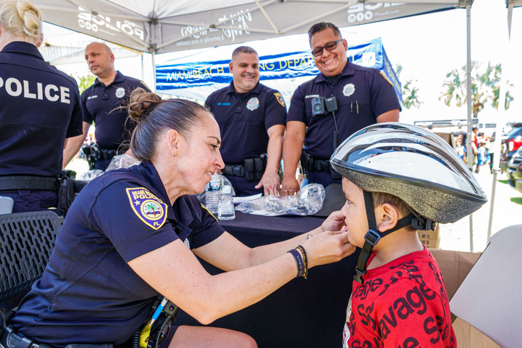Miami Beach, Florida, Annual Miami Beach Police Block Party, Flamingo Park, bicycle helmet giveaway, police fitting young boy with helmet