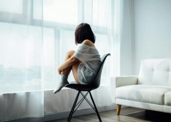 Lonely teenager looking out the window (Photo by Anthony Tran via Unsplash)