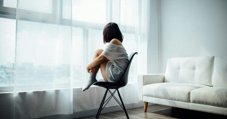 Lonely teenager looking out the window (Photo by Anthony Tran via Unsplash)