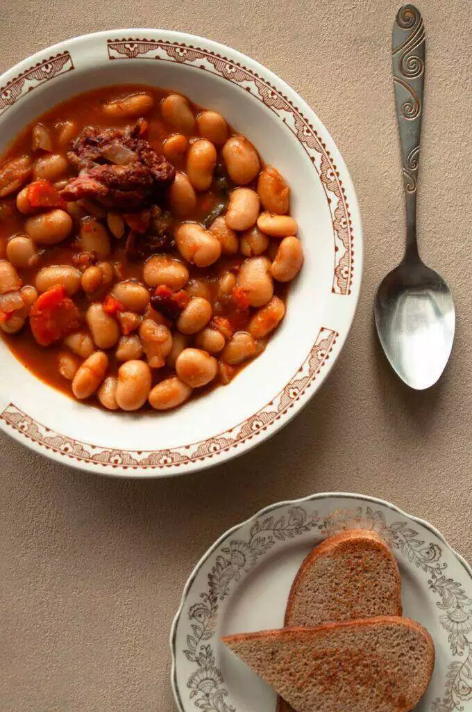 Satisfying bean stew served with slices of hearty bread, perfect for dinner.