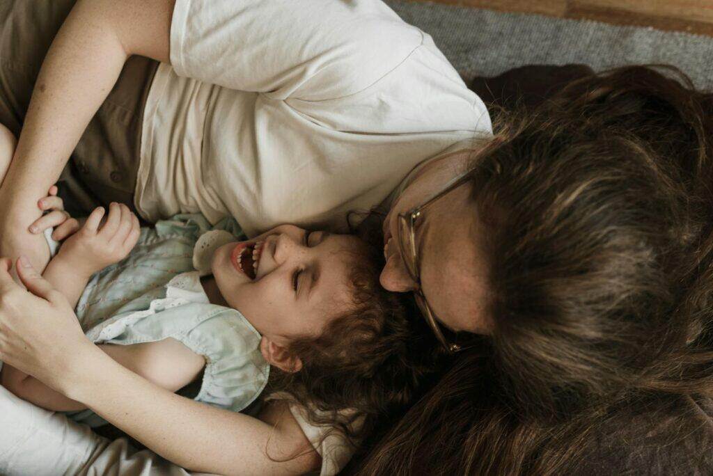 A loving mother embracing her laughing daughter, capturing a moment of joy and togetherness.