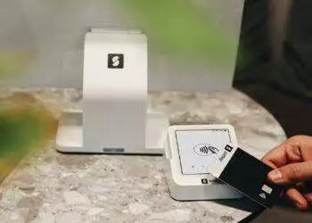A person holding a credit card in front of a computer