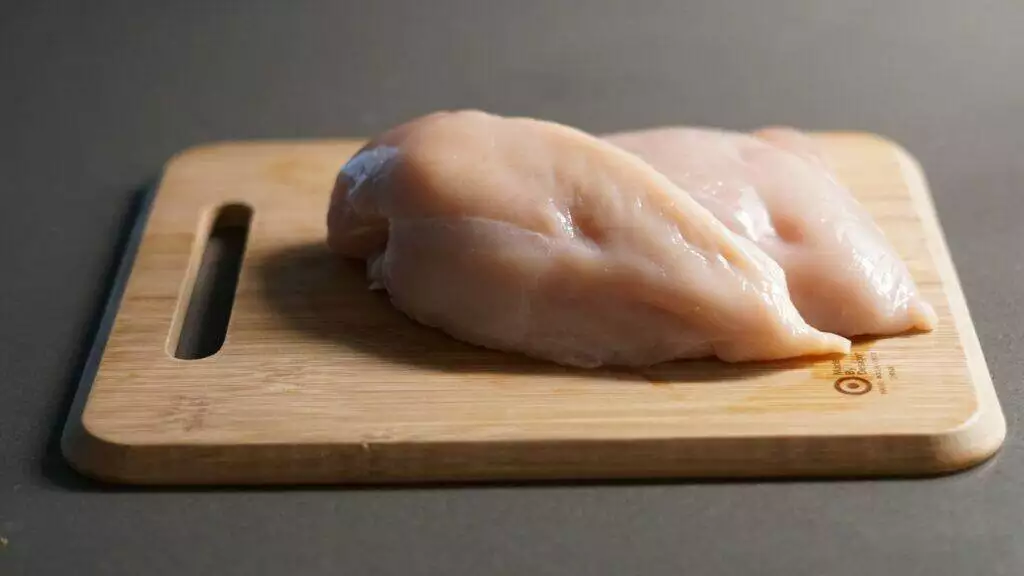 a piece of raw chicken on a cutting board