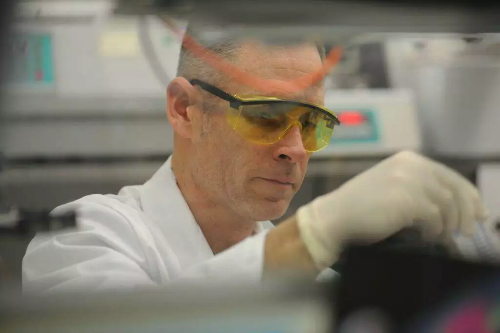 a man in a lab wearing safety goggles