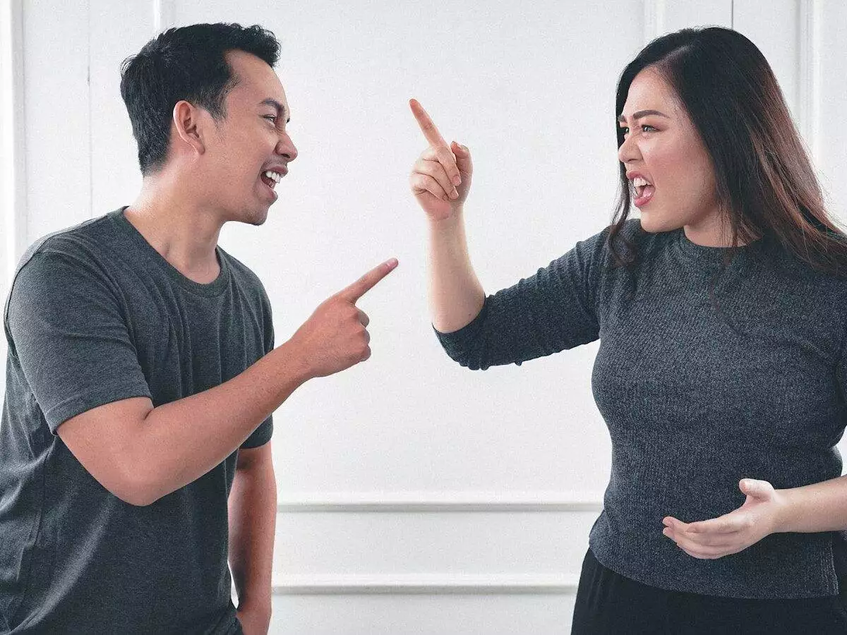 man in gray crew neck long sleeve shirt standing beside woman in black crew neck shirt
