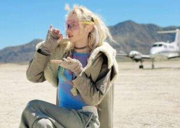 Grimes sitting on chair in the desert (Instagram | grimes)