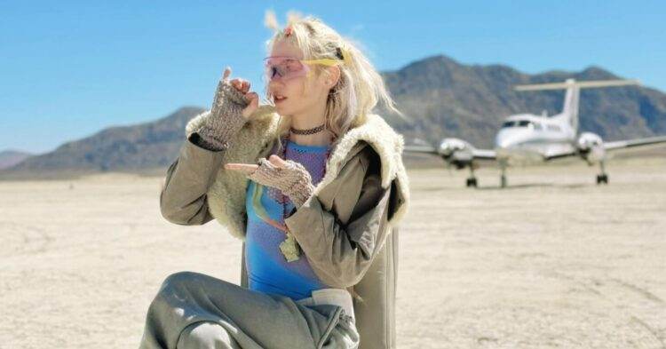 Grimes sitting on chair in the desert (Instagram | grimes)