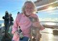 James May on a boat posing with a puppy dog.