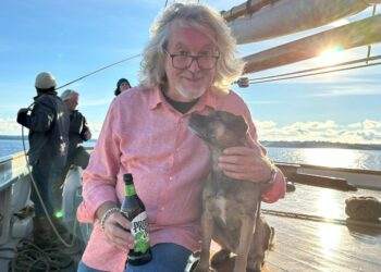 James May on a boat posing with a puppy dog.
