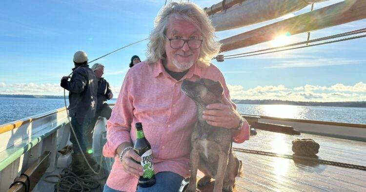 James May on a boat posing with a puppy dog.