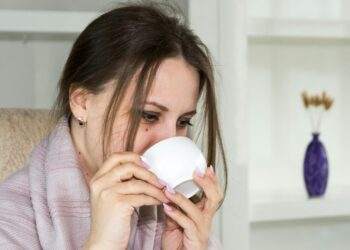 Woman sitting in a chari drinking from a mug (Unsplash | Bermix Studio)