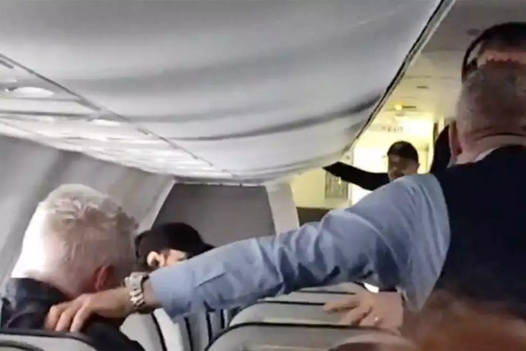 An Alaska Airlines flight attendant punches an unruly passenger in the throat and torso to force him to let go of a woman’s hair.
