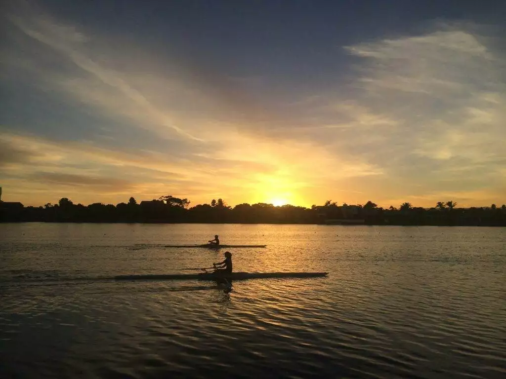 two people silhouette on body of water during golden hour